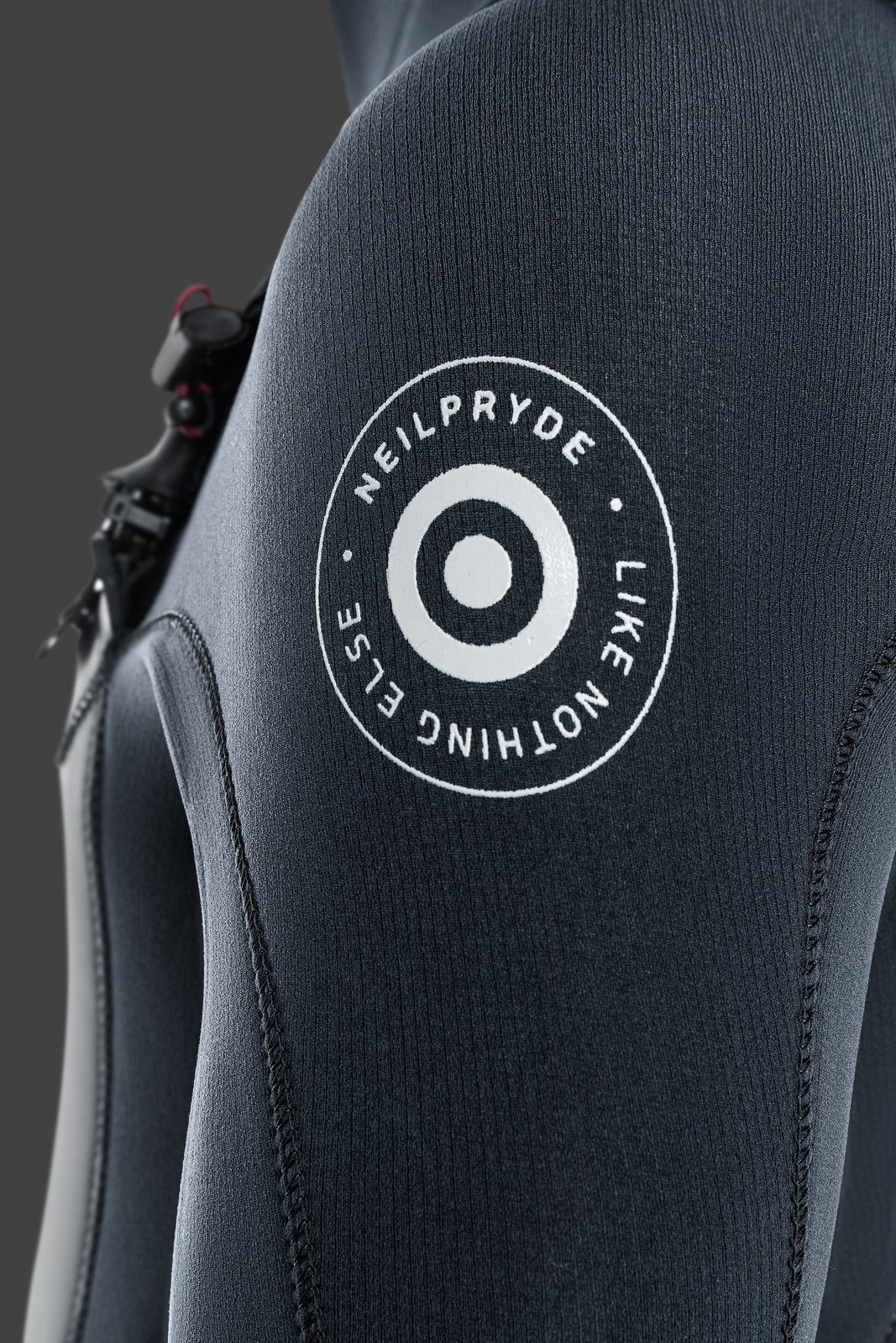 NeilPryde Combat Hooded 6/5 GBS téli neoprén ruha részlete a mellkasi logóval és a cipzárral
