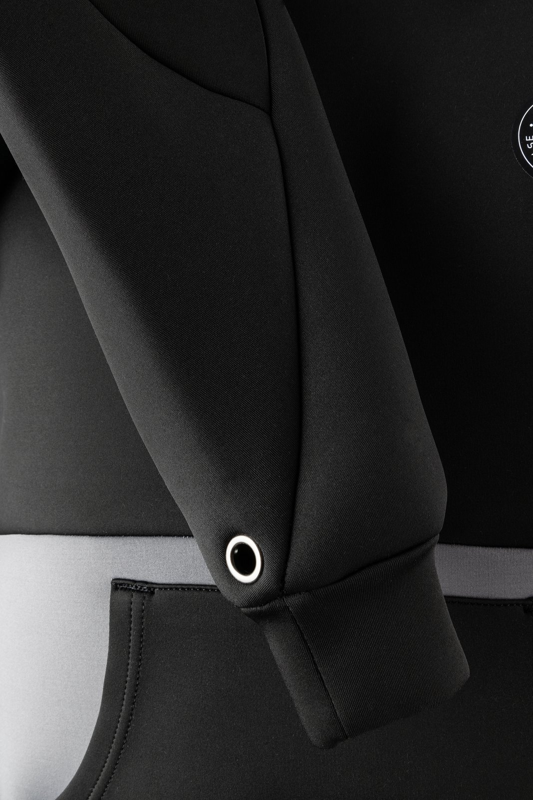 Fekete színű Neo Hoodie 2026 neoprén pulóver részletfotója, amely a vízparti vagy vízi használatra tervezett technikai anyagot mutatja