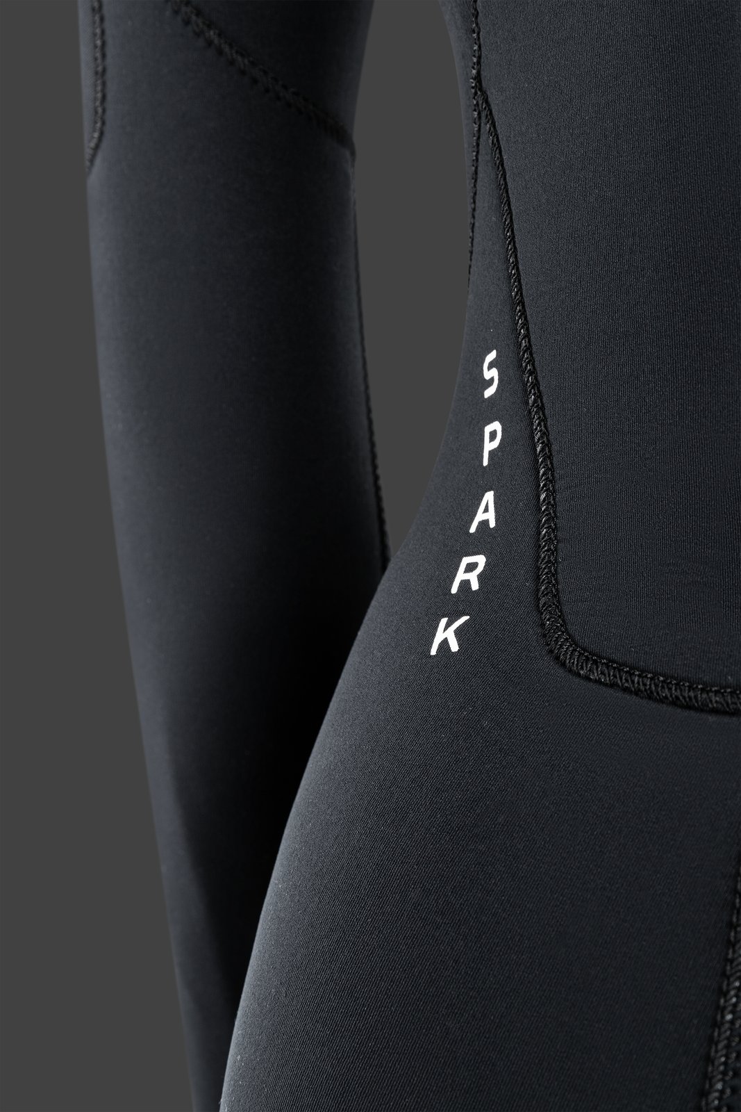 NeilPryde Spark 5/4 női szörfruha 2025-ös modell, részletfotó a neoprén anyag textúrájáról és a Spark feliratról