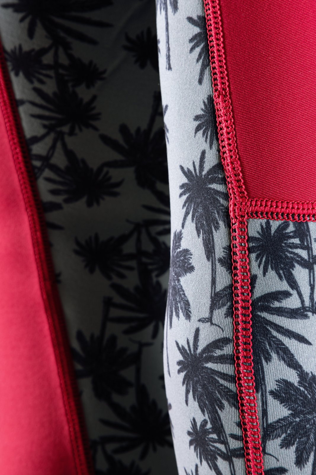 Vamp 2/2 Bikini Cut L/S FZ 2026 női neoprén ruha pálmamintás anyagának és piros varrásának közeli részlete